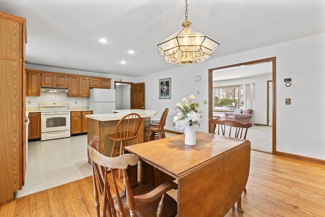 dining area featuring an inviting chandelier and light hardwood / wood-style flooring