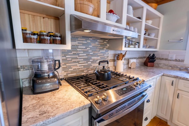 kitchen featuring white cabinetry, decorative backsplash, light stone counters, and stainless steel gas stove