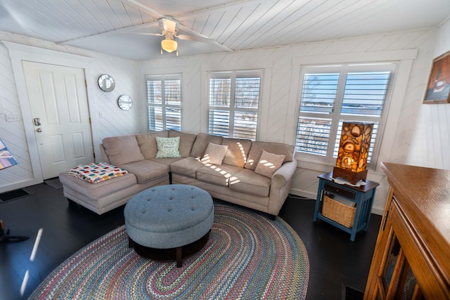 living room with dark wood-type flooring, ceiling fan, and wooden ceiling