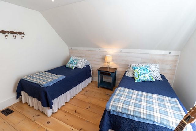 bedroom with hardwood / wood-style flooring and lofted ceiling