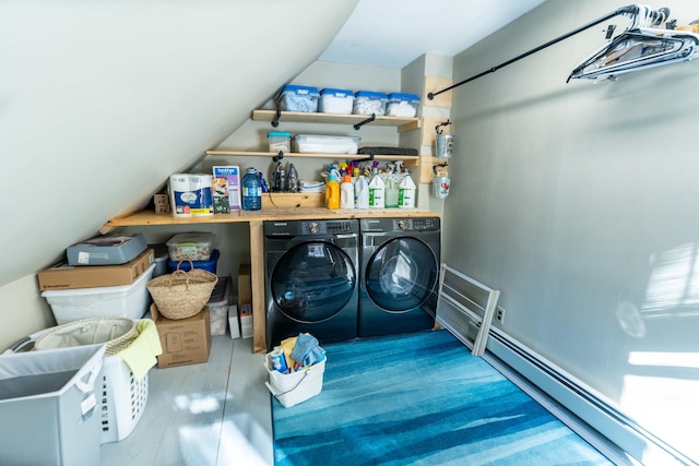 laundry room featuring wood-type flooring, washer and clothes dryer, and a baseboard heating unit