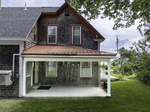 194 Water St, Eastport, ME 04631 - rear view of house featuring a yard, a shingled roof, a metal roof, a chimney, and a patio area