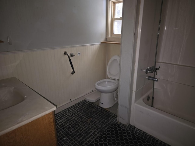 full bathroom featuring wooden walls, vanity, toilet, and tub / shower combination