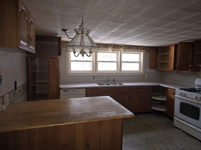 kitchen with an inviting chandelier, sink, white appliances, and decorative light fixtures