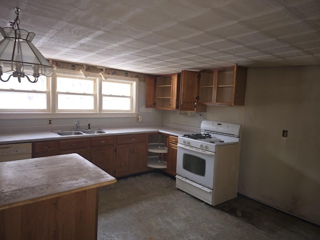 kitchen featuring white appliances, a chandelier, sink, and hanging light fixtures