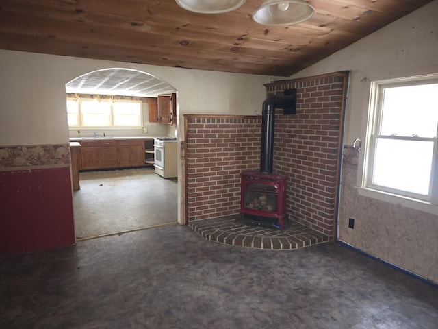 unfurnished living room featuring vaulted ceiling, wooden ceiling, sink, and a wood stove