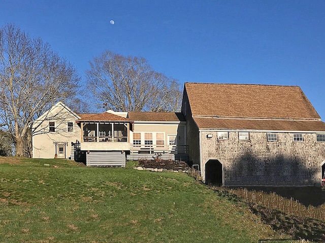 back of house featuring a sunroom and a lawn