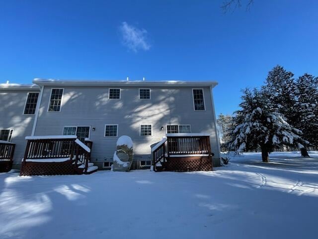 snow covered house featuring a deck