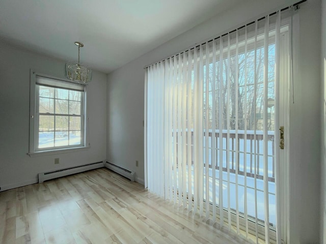 unfurnished dining area featuring light wood-type flooring and baseboard heating