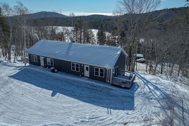 snow covered house featuring a mountain view