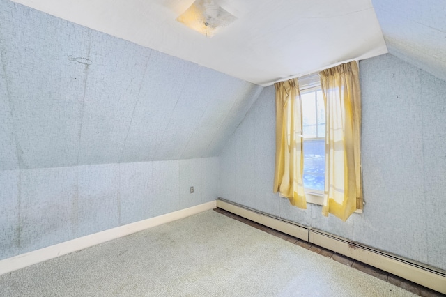 bonus room featuring a baseboard heating unit, vaulted ceiling, and carpet flooring