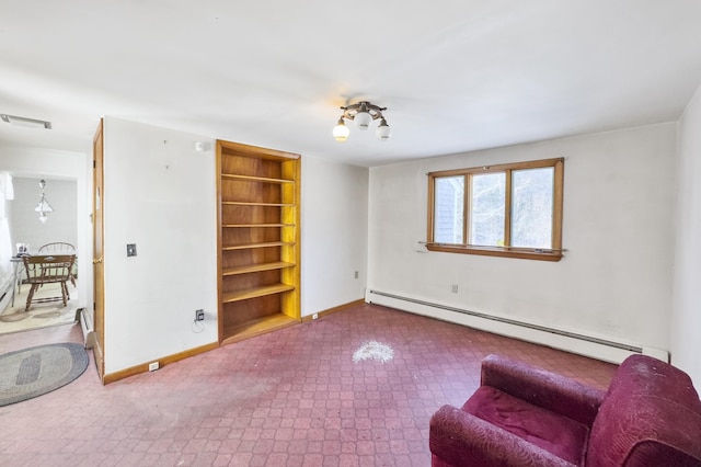 living area with baseboard heating and built in shelves