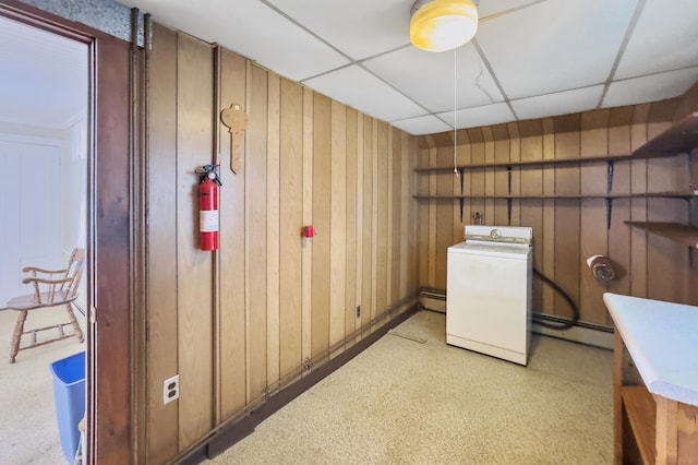 laundry room with wooden walls, washer / dryer, and a baseboard heating unit