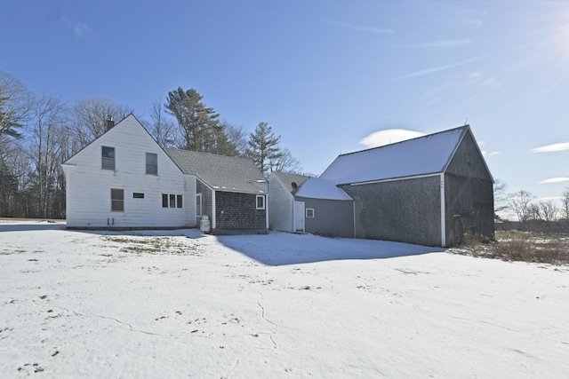 view of snow covered back of property