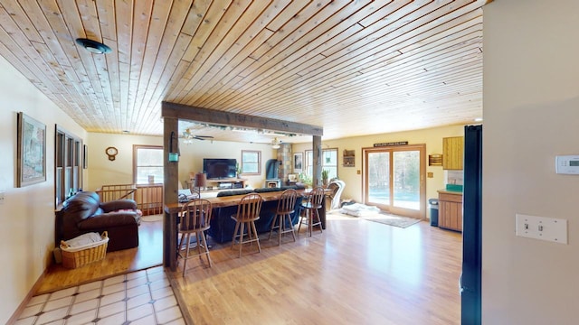 living room with wood ceiling, light hardwood / wood-style flooring, and ceiling fan