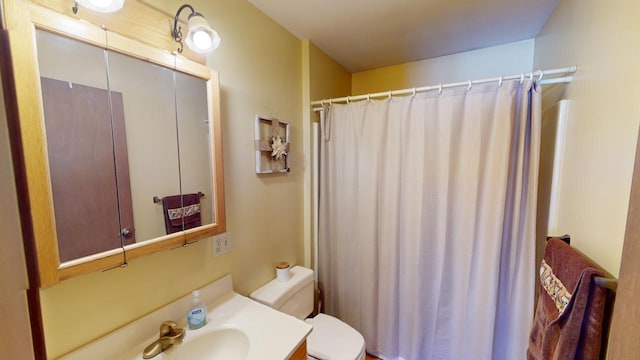 bathroom with vanity, a shower with shower curtain, and toilet