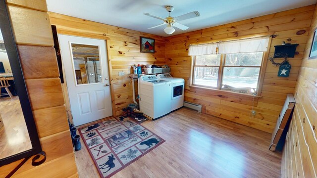 washroom featuring ceiling fan, independent washer and dryer, wood walls, and light wood-type flooring