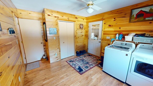 laundry room with separate washer and dryer, wooden walls, light hardwood / wood-style floors, and ceiling fan