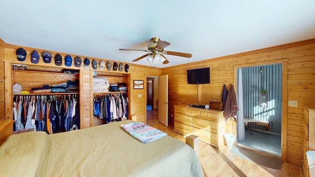 bedroom featuring ceiling fan, hardwood / wood-style floors, and wood walls