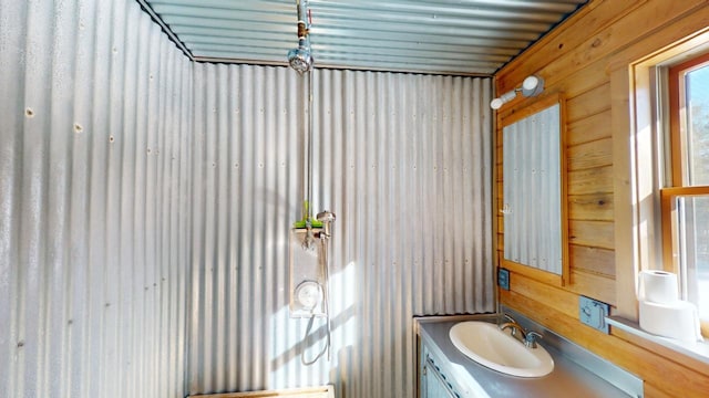 bathroom with vanity and wood walls