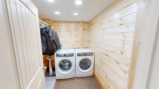 laundry room with wooden walls and independent washer and dryer