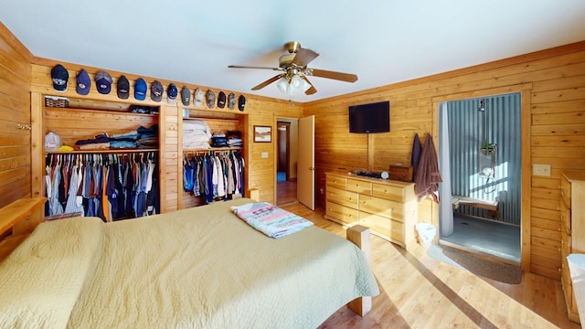 bedroom with hardwood / wood-style flooring, ceiling fan, and wood walls