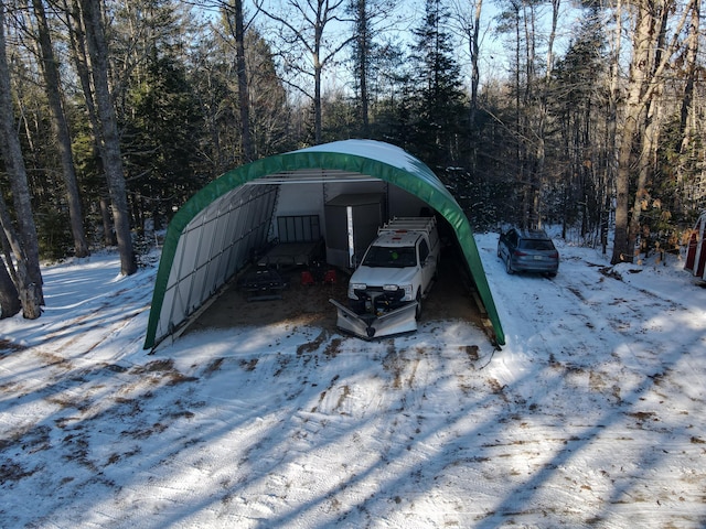 snow covered parking area featuring a carport