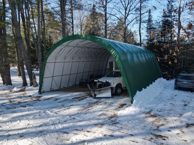 snow covered structure featuring a carport