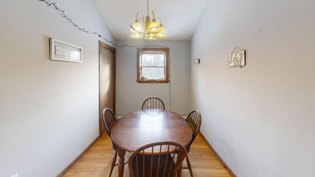 dining area with an inviting chandelier and light hardwood / wood-style floors