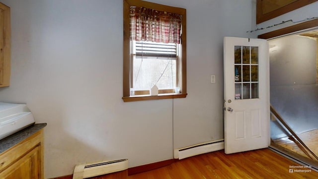 entryway with hardwood / wood-style floors and baseboard heating