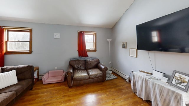 living room with hardwood / wood-style flooring, vaulted ceiling, and baseboard heating