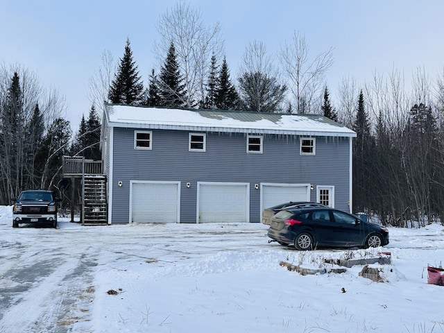 snow covered property with a garage