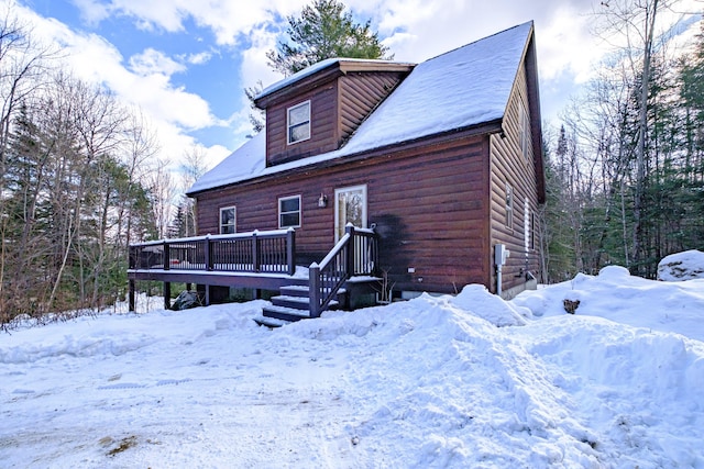 snow covered property with a deck