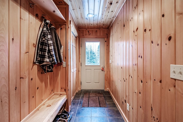 mudroom with wooden ceiling and wood walls