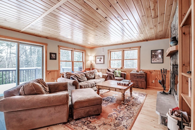 living room featuring wood ceiling, wooden walls, light hardwood / wood-style flooring, and crown molding