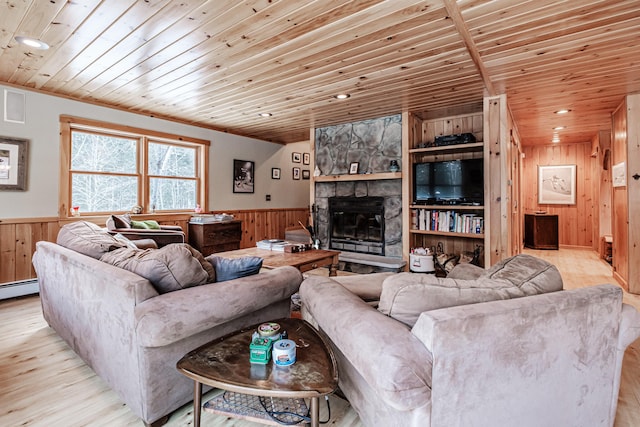 living room with a stone fireplace, built in features, wood ceiling, and light hardwood / wood-style flooring