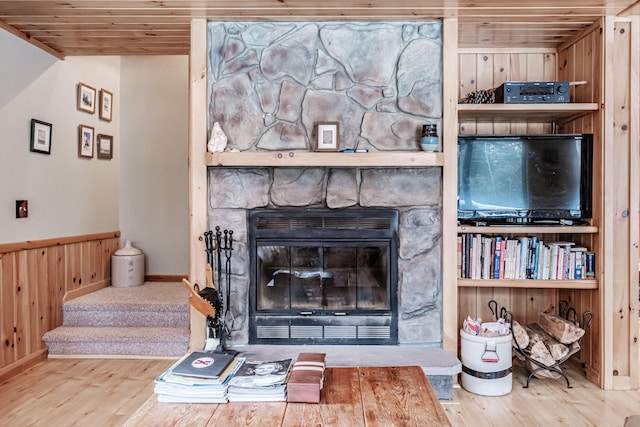 living room with wood ceiling, a fireplace, hardwood / wood-style flooring, and wood walls