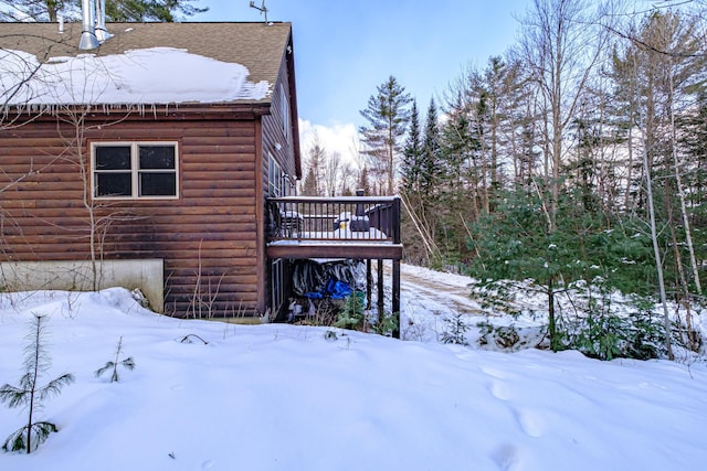 view of snowy exterior with a wooden deck