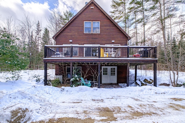 snow covered rear of property featuring a deck