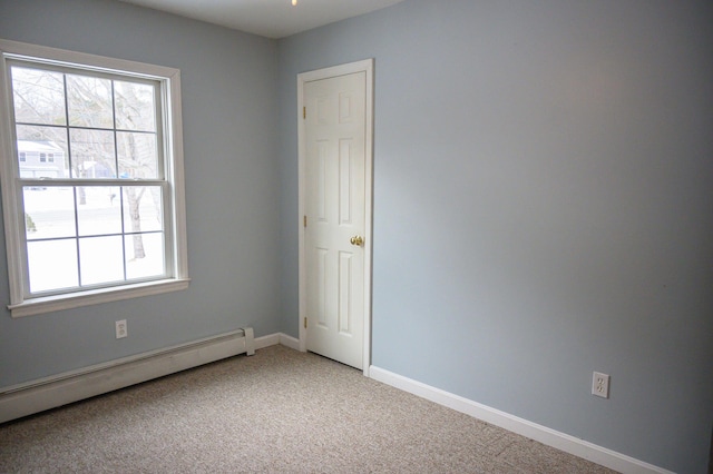 carpeted empty room featuring baseboard heating