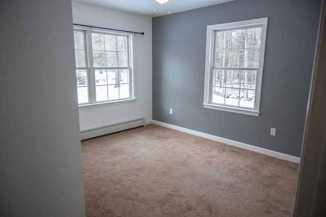 carpeted empty room with a baseboard heating unit and ceiling fan