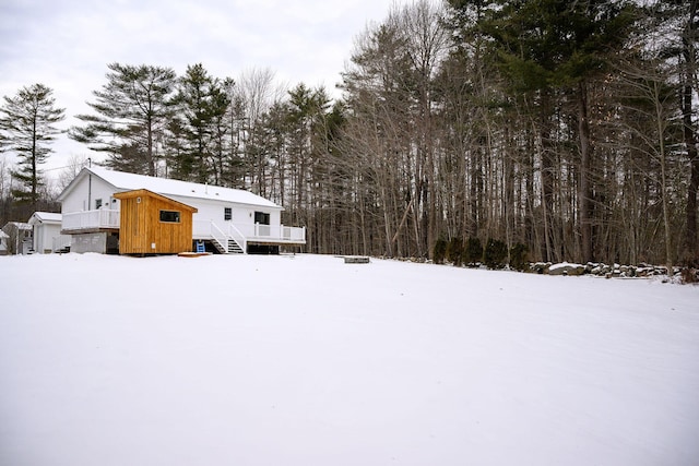 yard covered in snow featuring a deck