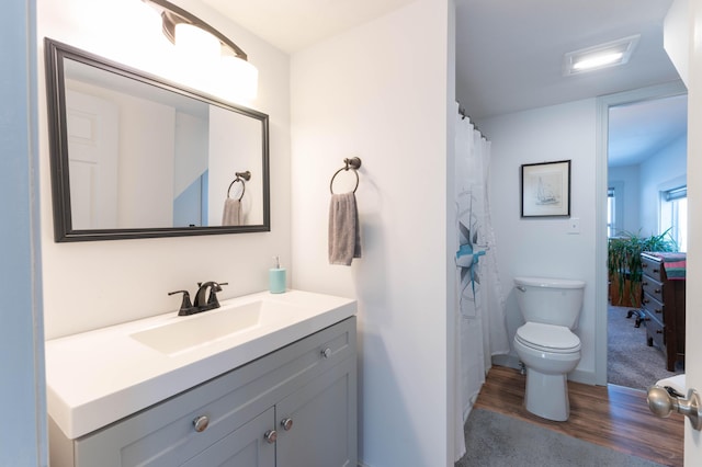 bathroom featuring hardwood / wood-style flooring, vanity, and toilet