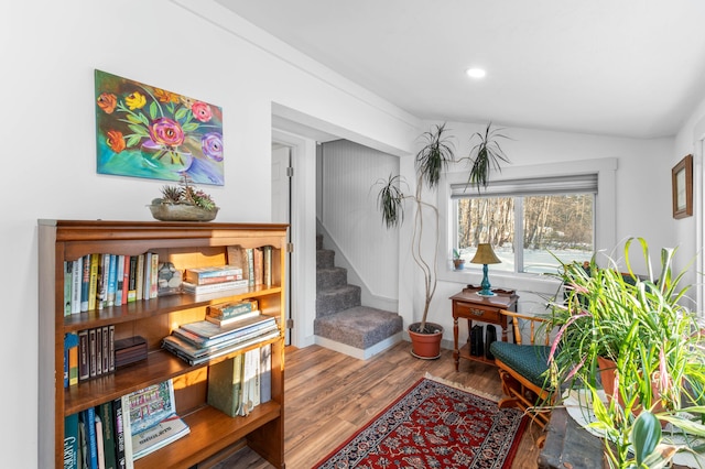 hallway with vaulted ceiling and hardwood / wood-style floors