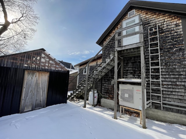 view of snow covered exterior with an outdoor structure