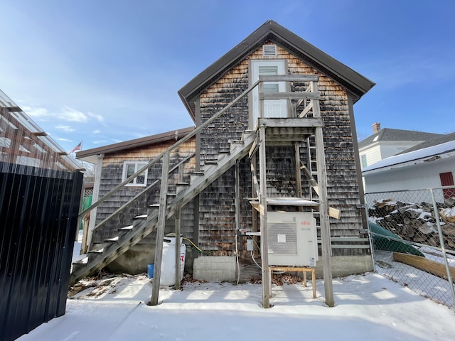 snow covered property with ac unit