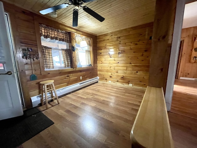 interior space with hardwood / wood-style floors, wood ceiling, wooden walls, and ceiling fan