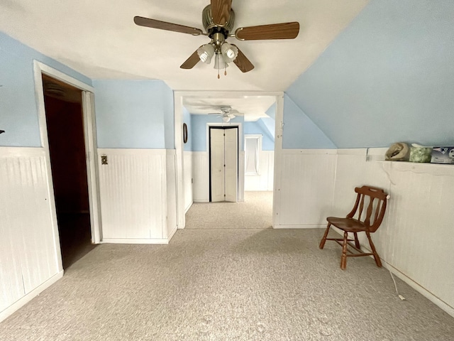 corridor featuring lofted ceiling and light carpet