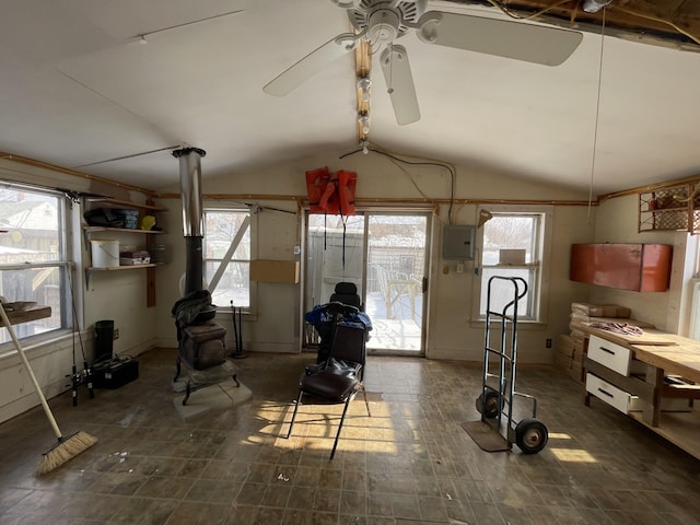 exercise room with vaulted ceiling, a healthy amount of sunlight, electric panel, and ceiling fan