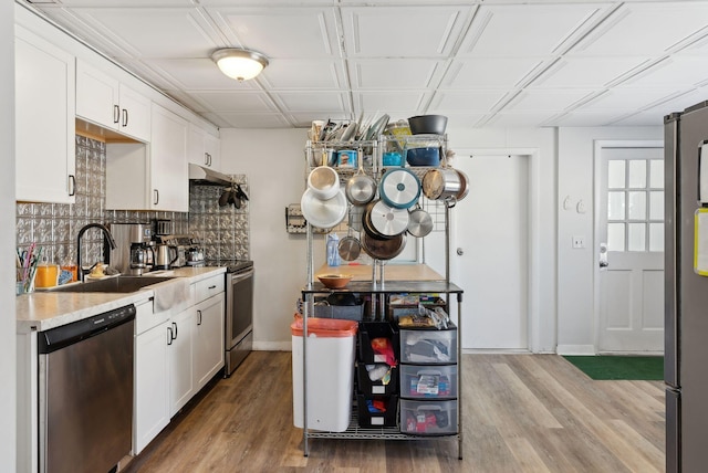 kitchen with backsplash, stainless steel appliances, sink, and white cabinets